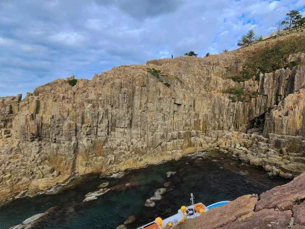 Tojinbo boat cove with clear water and cliffs